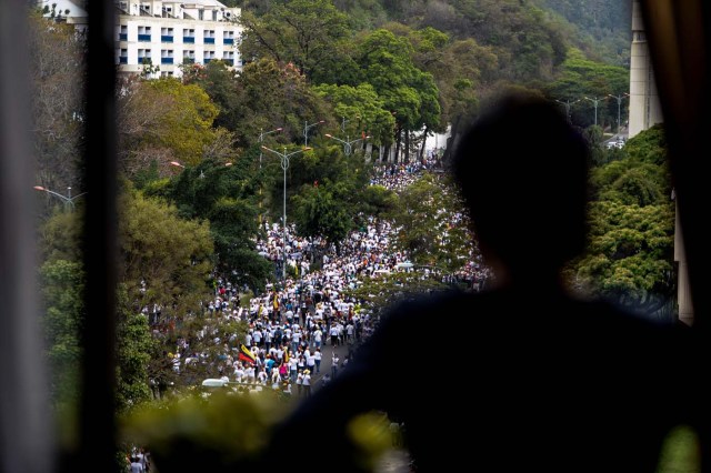 Venezuelan opposition activists march in a quiet show of condemnation of the government of President NIcolas Maduro, in Caracas, on April 22, 2017. Venezuelans gathered Saturday for "silent marches" against President Nicolas Maduro, a test of his government's tolerance for peaceful protests after three weeks of violent unrest that has left 20 people dead. / AFP PHOTO / FEDERICO PARRA