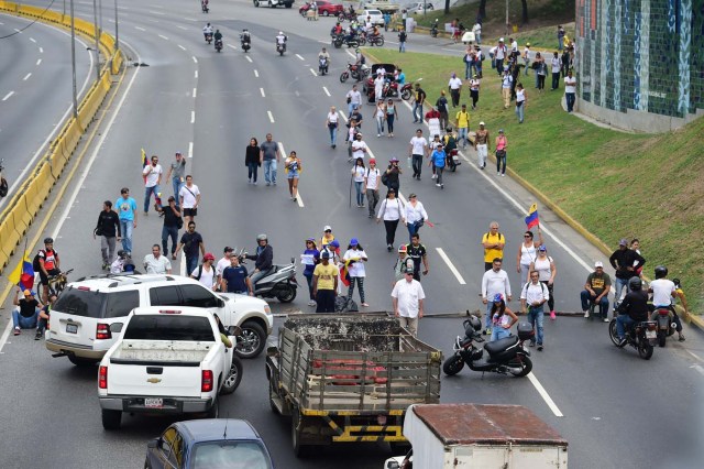 Venezuelan opposition activists block the Francisco Fajardo motorway in Caracas, on April 24, 2017. Protesters plan Monday to block Venezuela's main roads including the capital's biggest motorway, triggering fears of further violence after three weeks of unrest left 21 people dead. / AFP PHOTO / RONALDO SCHEMIDT
