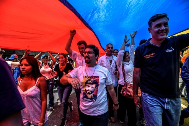 The first vice-president of Venezuela's National Assembly, Freddy Guevara (C), joins opposition activists marching against President Nicolas Maduro in Caracas, on April 24, 2017. Protesters rallied on Monday vowing to block Venezuela's main roads to raise pressure on Maduro after three weeks of deadly unrest that have left 21 people dead. Riot police fired rubber bullets and tear gas to break up one of the first rallies in eastern Caracas early Monday while other groups were gathering elsewhere, the opposition said.  / AFP PHOTO / Juan BARRETO