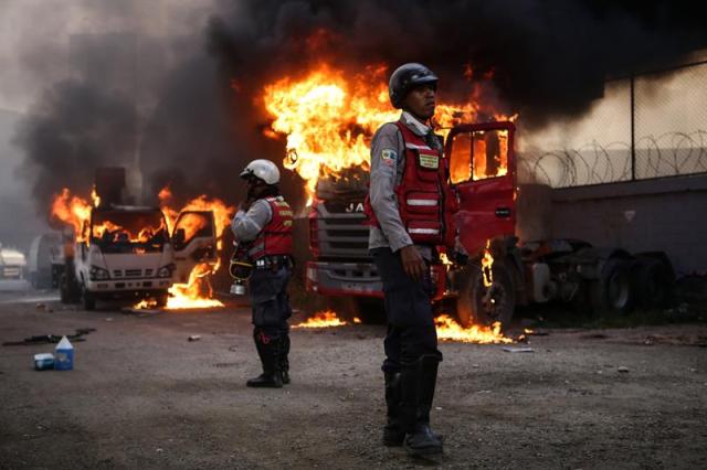 Personal de emergencias es visto junto a unos vehículos que se incendian durante una manifestación contra el Gobierno venezolano hoy, lunes 24 de abril de 2017. EFE/CRISTIAN HERNANDEZ