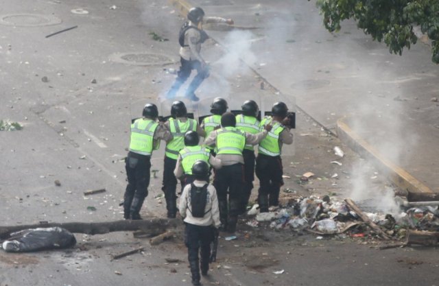 Esta secuencia fue captada durante las protestas de la oposición contra el Gobierno de Nicolás Maduro el pasado 8 de abril en Caracas, capital de Venezuela, en la avenida Francisco Solano, entre los municipios Chacao y Libertador, este último gobernado por el dirigente chavista Jorge Rodríguez. Las fotografías, tomadas desde el mismo ángulo, muestran la intervención de las fuerzas de seguridad en la movilización y su proximidad a los grupos armados afines al oficialismo. En la imagen, un grupo de oficiales de la Policía Nacional Bolivariana se enfrenta a manifestantes opositores. RAÚL ROMERO 