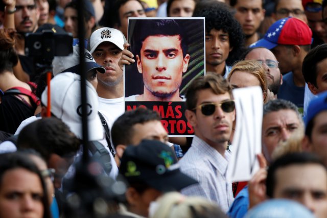 Opposition supporters hold a picture of Juan Pablo Pernalete, who died after being hit by a tear gas shot during a protest against Venezuelan President Nicolas Maduro, at a tribute to him in Caracas, Venezuela April 27, 2017. REUTERS/Carlos Garcia Rawlins