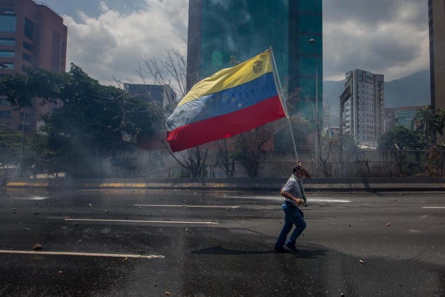 CAR01. CARACAS (VENEZUELA), 26/04/2017.- Venezolanos participan en una manifestación hoy, miércoles 26 de abril de 2017, en Caracas (Venezuela). Las fuerzas de seguridad de Venezuela dispersaron nuevamente algunas de las marchas convocadas por la oposición en Caracas, que pretendían llegar a la sede principal de la Defensoría del Pueblo en el centro de la capital. EFE/MIGUEL GUTIÉRREZ