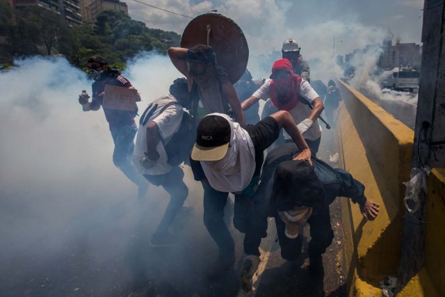 CAR01. CARACAS (VENEZUELA), 26/04/2017.- Venezolanos participan en una manifestación hoy, miércoles 26 de abril de 2017, en Caracas (Venezuela). Las fuerzas de seguridad de Venezuela dispersaron nuevamente algunas de las marchas convocadas por la oposición en Caracas, que pretendían llegar a la sede principal de la Defensoría del Pueblo en el centro de la capital. EFE/MIGUEL GUTIÉRREZ