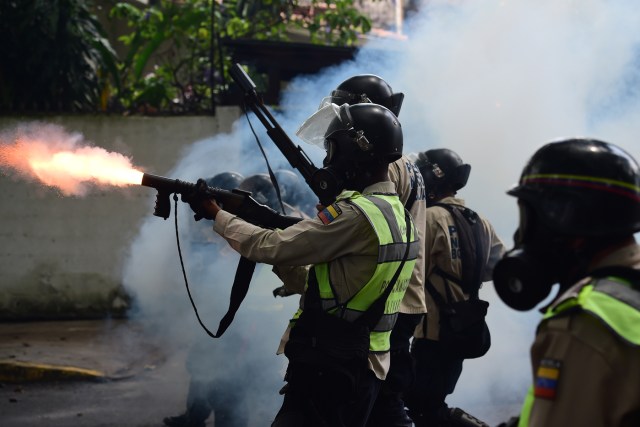 Oficial de la PNB disparando bomba lacrimógena en dirección a manifestantes opositores en la avenida La Victoria el lunes 1 de mayor de 2017. Foto: AFP
