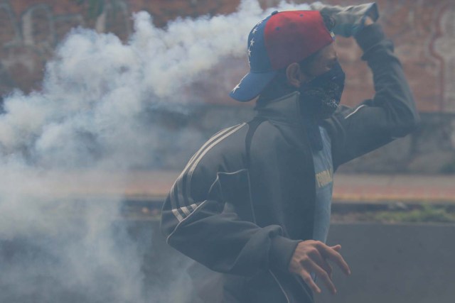 A demonstrator throws back a tear gas canister during a protest against Venezuela's President Nicolas Maduro's government in Caracas, Venezuela May 2, 2017. REUTERS/Carlos Garcia Rawlins