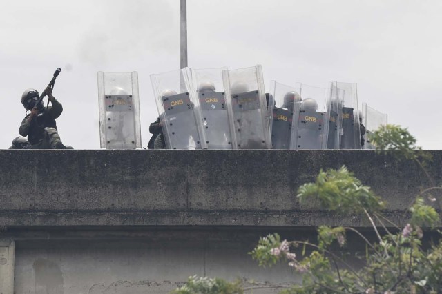 Riot police agents fire tear gas to demonstrators during a protest against Venezuelan President Nicolas Maduro, in Caracas on May 3, 2017. Venezuela's angry opposition rallied Wednesday vowing huge street protests against President Nicolas Maduro's plan to rewrite the constitution and accusing him of dodging elections to cling to power despite deadly unrest. / AFP PHOTO / JUAN BARRETO