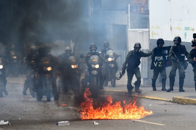 Venezuelan National Guard personnel in riot gear clash with opposition demonstrators during a protest against Venezuelan President Nicolas Maduro, in Caracas on May 3, 2017. Venezuela's angry opposition rallied Wednesday vowing huge street protests against President Nicolas Maduro's plan to rewrite the constitution and accusing him of dodging elections to cling to power despite deadly unrest. / AFP PHOTO / RONALDO SCHEMIDT