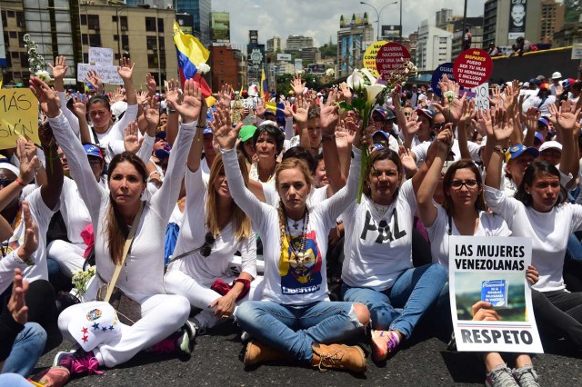 The wife of imprisoned opposition leader Leopoldo Lopez, Lilian Tintori (C), takes part in a women's march aimed to keep pressure on President Nicolas Maduro, whose authority is being increasingly challenged by protests and deadly unrest, in Caracas on May 6, 2017. The death toll since April, when the protests intensified after Maduro's administration and the courts stepped up efforts to undermine the opposition, is at least 36 according to prosecutors. / AFP PHOTO / RONALDO SCHEMIDT