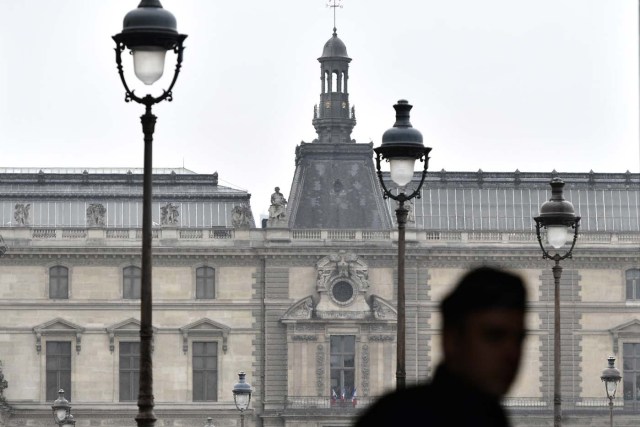 A police officer patrols the Louvre Museum in Paris, on May 7, 2017, following an evacuation due to a security alert, during the second round of voting for the French presidential election. The esplanade of the Louvre, where French presidential frontrunner Emmanuel Macron planned a rally in then event of victory in the elections, was evacuated May 7 in the early afternoon due to a security alert, according to a police source. / AFP PHOTO / PHILIPPE LOPEZ
