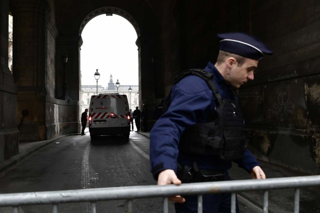A police officer barricades an entrance to the courtyard of the Louvre Museum in Paris, on May 7, 2017, following an evacuation due to a security alert, during the second round of voting for the French presidential election. The esplanade of the Louvre, where Emmanuel Macron planned a rally in case of victory in the presidential election, was evacuated May 7 in the early afternoon due to a security alert, according to a police source. / AFP PHOTO / PHILIPPE LOPEZ