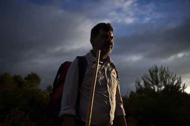 Carlos Gil starts his walk to Fatima with a backpack on his shoulders, in Cascais, outskirts of Lisbon, on May 5, 2017.   Carlos Gil is a payer-off of promises, at least that is the way the Roman Catholic refers to himself. But he is more commonly known as a rent-a-pilgrim. This 52-year-old Portuguese national takes on pilgrimages by proxy (in the name of others), especially Catholics unable to fulfil the journey because of sickness or too busy or lazy to undertake the week-long spiritual walk to the central Portuguese town of Fatima. He can be hired for an average cost of 2,500 euros. / AFP PHOTO / PATRICIA DE MELO MOREIRA / TO GO WITH AFP STORY BY BRIGITTE HAGEMANN