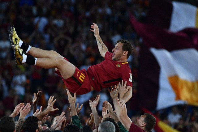 AS Roma players celebrate Roma's captain Francesco Totti during a ceremony following his last match with AS Roma after the Italian Serie A football match AS Roma vs Genoa on May 28, 2017 at the Olympic Stadium in Rome. Italian football icon Francesco Totti retired from Serie A after 25 seasons with Roma, in the process joining a select group of 'one-club' players. / AFP PHOTO / Vincenzo PINTO