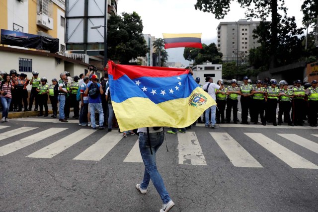 A woman holds up a flag during a women's march to protest against President Nicolas Maduro's government in Caracas, Venezuela May 6, 2017. REUTERS/Carlos Garcia Rawlins