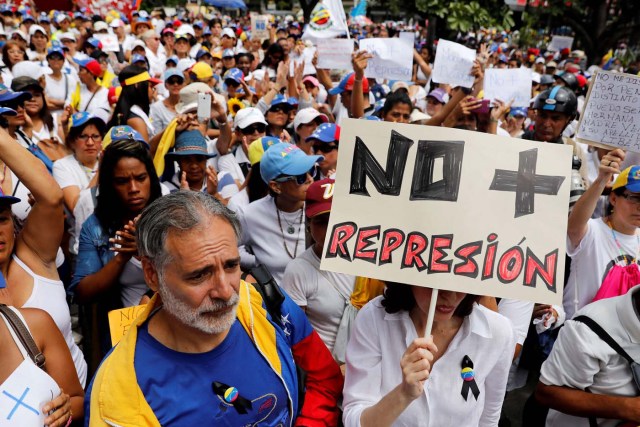 A woman holds up a placard that reads "No more repression" during a women's march to protest against President Nicolas Maduro's government in Caracas, Venezuela May 6, 2017. REUTERS/Carlos Garcia Rawlins