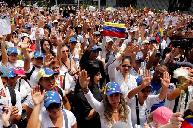 Women lift their hands as they attend a women's march to protest against President Nicolas Maduro's government in Caracas, Venezuela May 6, 2017. REUTERS/Carlos Garcia Rawlins