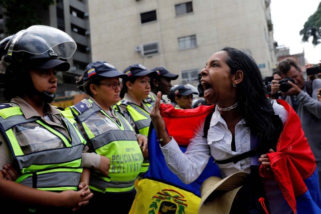 A demonstrator shouts slogans in front of police officers during a women's march to protest against President Nicolas Maduro's government in Caracas, Venezuela May 6, 2017. REUTERS/Carlos Garcia Rawlins