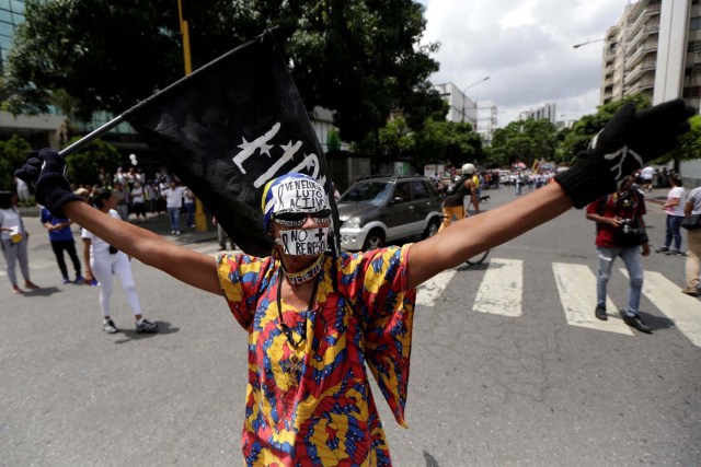 A demonstrator covers his mouth with a sticker that reads "No more repression" during a women's march to protest against President Nicolas Maduro's government in Caracas, Venezuela, May 6, 2017. REUTERS/Marco Bello