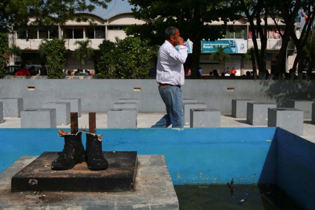 A man walks past the remains of a statue of Venezuela's late President Hugo Chavez after it was destroyed in La Villa del Rosario, Venezuela May 6, 2017. REUTERS/Isaac Urrutia EDITORIAL USE ONLY. NO RESALES. NO ARCHIVE.
