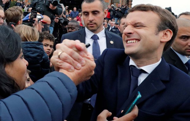 French presidential election candidate Emmanuel Macron, head of the political movement En Marche !, or Onwards ! greets supporters as leaves a polling station during the the second round of 2017 French presidential election, in Le Touquet, France, May 7, 2017. REUTERS/Philippe Wojazer      TPX IMAGES OF THE DAY
