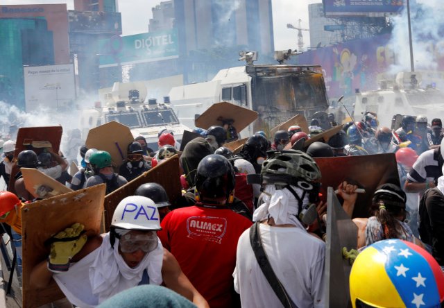 Opposition supporters clash with riot security forces while rallying against President Nicolas Maduro in Caracas
