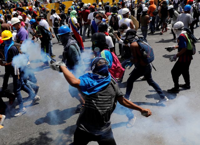 Opposition supporters clash with riot security forces while rallying against President Nicolas Maduro in Caracas