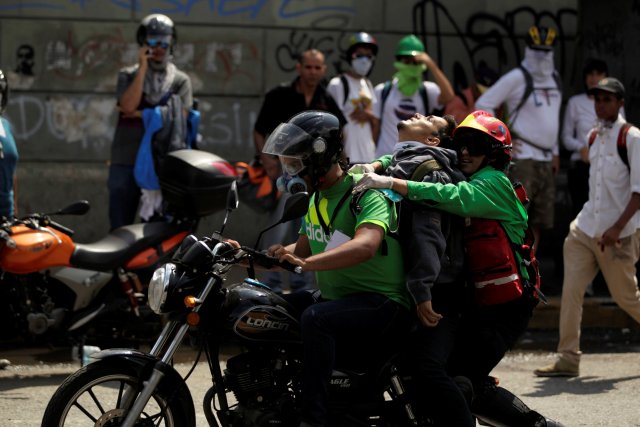 Momento en el que trasladaban al joven, Miguel Castillo hacia la Policlínica Las Mercedes. REUTERS/Christian Veron
