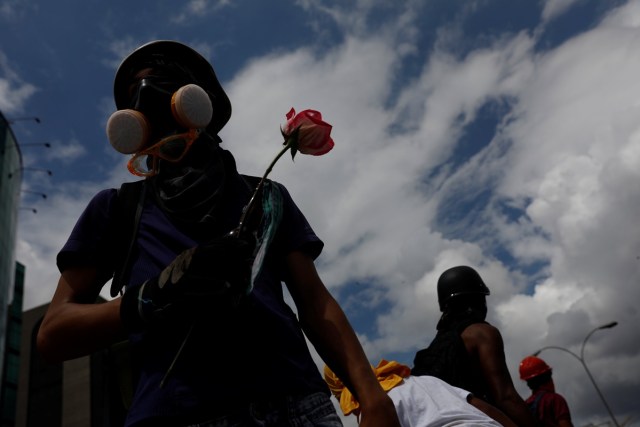 A demonstrator holds a flower during a protest against Venezuela's President Nicolas Maduro's government in Caracas, Venezuela, May 13, 2017. REUTERS/Carlos Garcia Rawlins