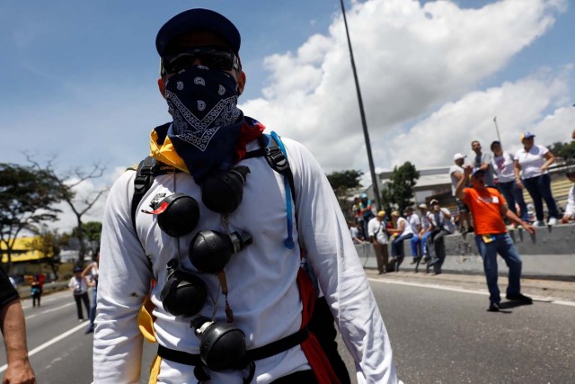 An opposition supporter rallies against President Nicolas Maduro with used tear gas grenades tied around his neck in Caracas, Venezuela, May 20, 2017. REUTERS/Carlos Garcia Rawlins