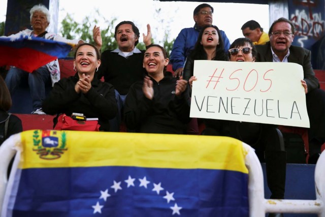 People holding a sign reads; ' SOS Venezuela' attend a protest against a visit by Venezuela's President Nicolas Maduro to Ecuador to attend President Lenin Moreno's inauguration, in Quito, Ecuador, May 23, 2017. REUTERS/Mariana Bazo