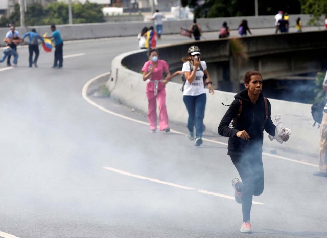 Demonstrators run away while clashing with riot security forces during a rally against President Nicolas Maduro in Caracas, Venezuela, May 24, 2017. REUTERS/Marco Bello