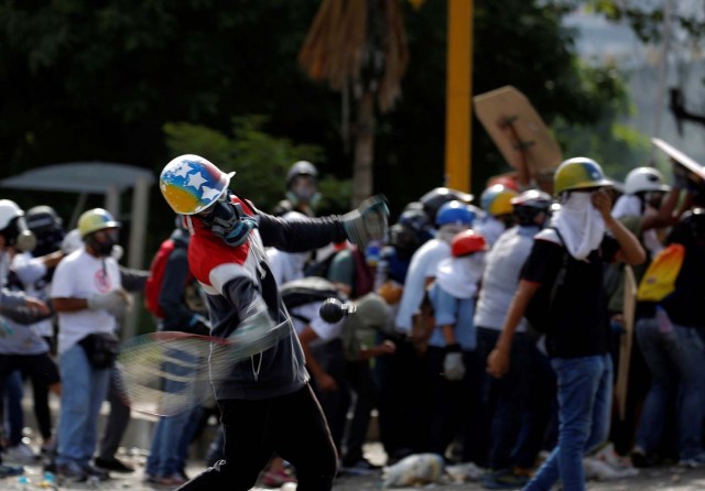 A demonstrator uses a racket to hit a tear gas canister while clashing with riot security forces during a rally against President Nicolas Maduro in Caracas, Venezuela, May 24, 2017. REUTERS/Carlos Barria