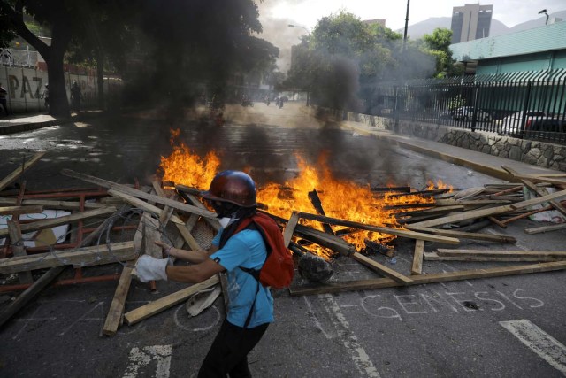 A demonstrator walks in front of a fire barricade while clashing with riot security forces during a rally against President Nicolas Maduro in Caracas, Venezuela, May 24, 2017. REUTERS/Carlos Barria
