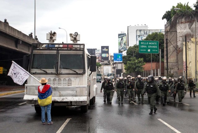 -FOTODELDIA-CAR009. CARACAS (VENEZUELA), 03/05/2017 - Una mujer bloquea el paso de una tanqueta de la Guardia Nacional durante una manifestación encabezada por diputados opositores hoy, miércoles 3 de mayo de 2017, en Caracas (Venezuela). La Guardia Nacional Bolivariana (GNB, policía militarizada) de Venezuela dispersó hoy con gases lacrimógenos una movilización opositora en el este de Caracas que pretendía llegar hasta la sede de la Asamblea Nacional (AN, Parlamento), ubicada en el centro de la capital. EFE/MIGUEL GUTIERREZ