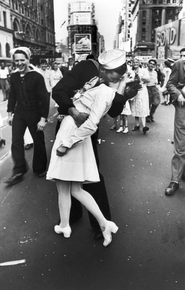 Se dio el 14 de agosto de 1945, cuando se anunció el fin de la Segunda Guerra Mundial. En Nueva York todos fueron a las calles a celebrar y el fotógrafo Alfred Eisenstaedt capturó el momento en que un marinero besó a una enfermera. Los protagonistas del beso no se conocían. Según el New York Times, la enfermera era Greta Friedman y Carl Muscarello aseguró ser el marinero.