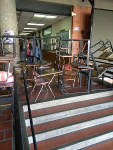 Estudiantes de la Metropolitana bloquean los accesos a las aulas con pupitres en forma de protesta