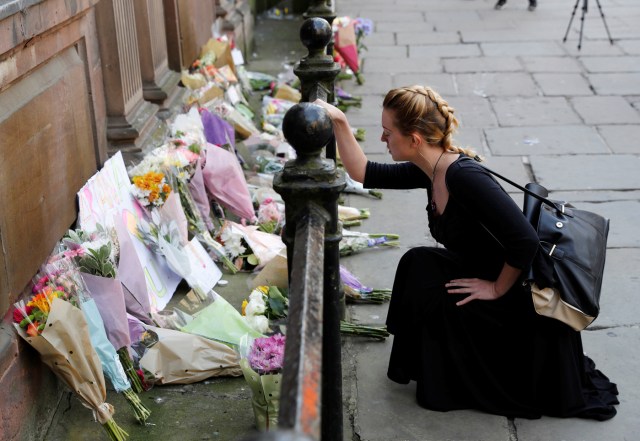 Una mujer deja flores en homenaje a las víctimas del atentado en Manchester. Foto: Reuters