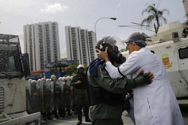 Un médico abraza a un miembro de la Guardia Nacional de Venezuela durante una manifestación convocada por trabajadores de la salud y activistas de la oposición contra el presidente Nicolás Maduro, en Caracas, Venezuela, 22 de mayo de 2017. REUTERS/Carlos Barria