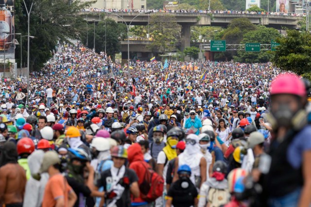 Opposition activists march during a protest against the government of President Nicolas Maduro in Caracas on May 31, 2017. Venezuelan authorities on Wednesday began signing up candidates for a planned constitutional reform body, a move that has inflamed deadly unrest stemming from anti-government protests. Opponents of socialist President Nicolas Maduro say he aims to keep himself in power by stacking the planned "constituent assembly" with his allies. / AFP PHOTO / FEDERICO PARRA