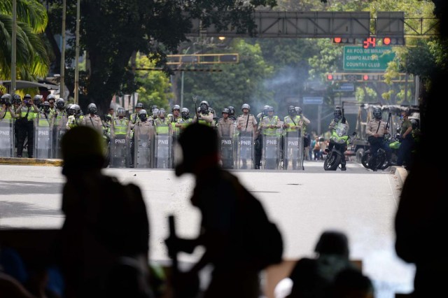 Opposition activists clash with riot police during an anti-government protest in Caracas, on June 22, 2017. / AFP PHOTO / Federico Parra