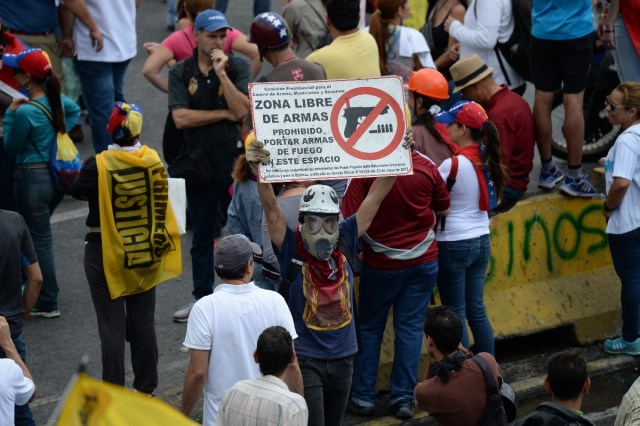 Opposition activists demonstrate against the government of Venezuelan President Nicolas Maduro in Caracas on June 24, 2017, in front of the Francisco de Miranda air force base near the place where a young man was shot dead by police during an anti-government rally two days ago. A political and economic crisis in the oil-producing country has spawned often violent demonstrations by protesters demanding Maduro's resignation and new elections. The unrest has left 75 people dead since April 1. / AFP PHOTO / Federico PARRA