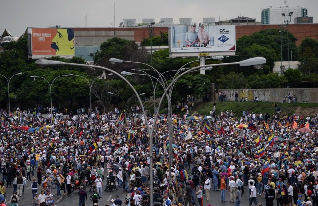 Opposition activists demonstrate against the government of Venezuelan President Nicolas Maduro in Caracas on June 24, 2017, in front of the Francisco de Miranda air force base near the place where a young man was shot dead by police during an anti-government rally two days ago. A political and economic crisis in the oil-producing country has spawned often violent demonstrations by protesters demanding Maduro's resignation and new elections. The unrest has left 75 people dead since April 1. / AFP PHOTO / Federico PARRA
