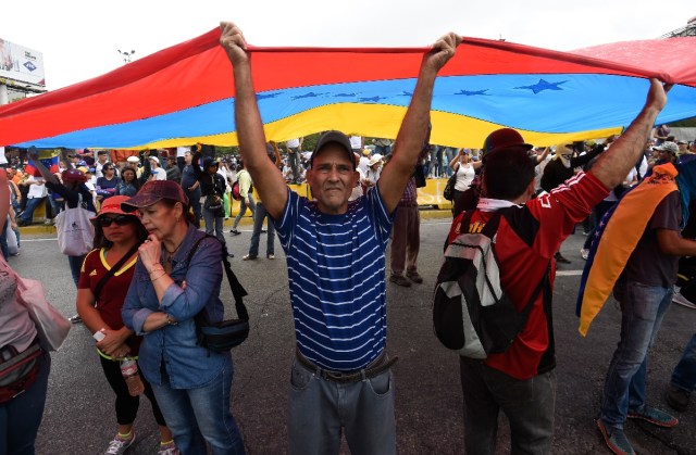 Opposition activists demonstrate against the government of Venezuelan President Nicolas Maduro in Caracas on June 24, 2017, in front of the Francisco de Miranda air force base near the place where a young man was shot dead by police during an anti-government rally two days ago. A political and economic crisis in the oil-producing country has spawned often violent demonstrations by protesters demanding Maduro's resignation and new elections. The unrest has left 75 people dead since April 1. / AFP PHOTO / Juan BARRETO