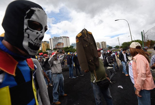 Opposition activists demonstrate against the government of Venezuelan President Nicolas Maduro in Caracas on June 24, 2017, in front of the Francisco de Miranda air force base near the place where a young man was shot dead by police during an anti-government rally two days ago. A political and economic crisis in the oil-producing country has spawned often violent demonstrations by protesters demanding Maduro's resignation and new elections. The unrest has left 75 people dead since April 1. / AFP PHOTO / Juan BARRETO