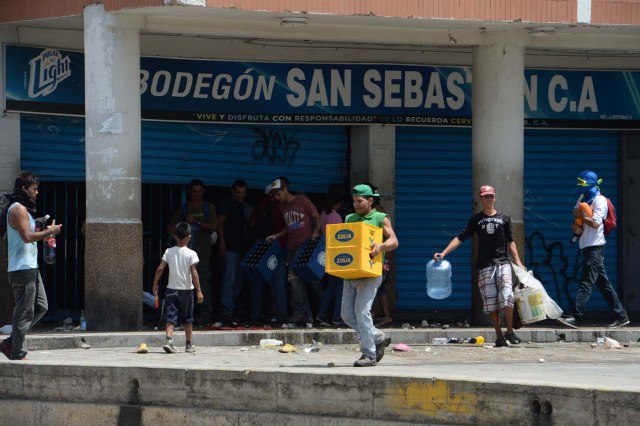 People loot a supermarket in Maracay, Aragua state, Venezuela on June 27, 2017. / AFP PHOTO / Federico Parra