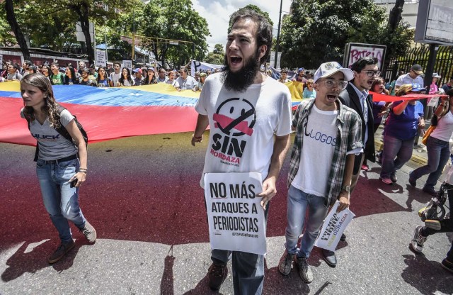 Journalists and media workers chant slogans during a demonstration against the attacks on journalists in Caracas on June 27, 2017. / AFP PHOTO / JUAN BARRETO