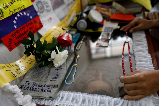 A mourner of Neomar Lander, who died during a protest against Venezuelan President Nicolas Maduro’s government, touches the coffin with his body in Guarenas, Venezuela June 9, 2017. REUTERS/Carlos Garcia Rawlins