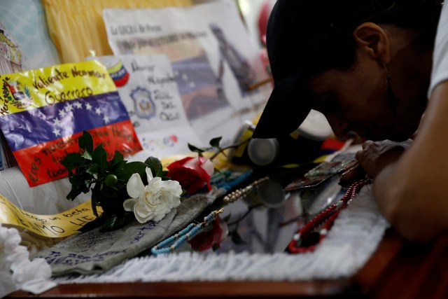 A mourner of Neomar Lander, who died during a protest against Venezuelan President Nicolas Maduro’s government, touches the coffin with his body in Guarenas, Venezuela June 9, 2017. REUTERS/Carlos Garcia Rawlins