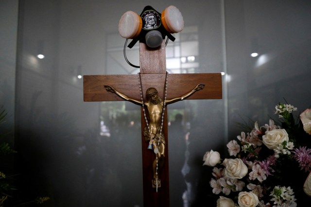 A tear gas mask hangs on a crucifix over a coffin (not pictured) at the funeral of Neomar Lander, who died during a protest against Venezuelan President Nicolas Maduro’s government, in Guarenas, Venezuela June 9, 2017. REUTERS/Carlos Garcia Rawlins TPX IMAGES OF THE DAY