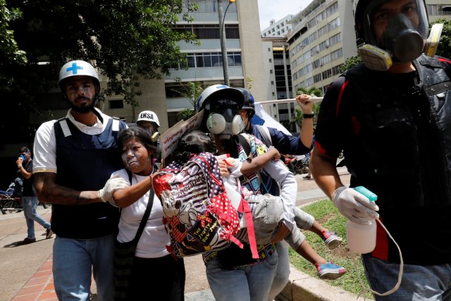 Voluntarios paramédicos rescatan a uno de los menores que resultaron afectados por los gases lacrimógenos en Altamira. REUTERS/Carlos Garcia Rawlins